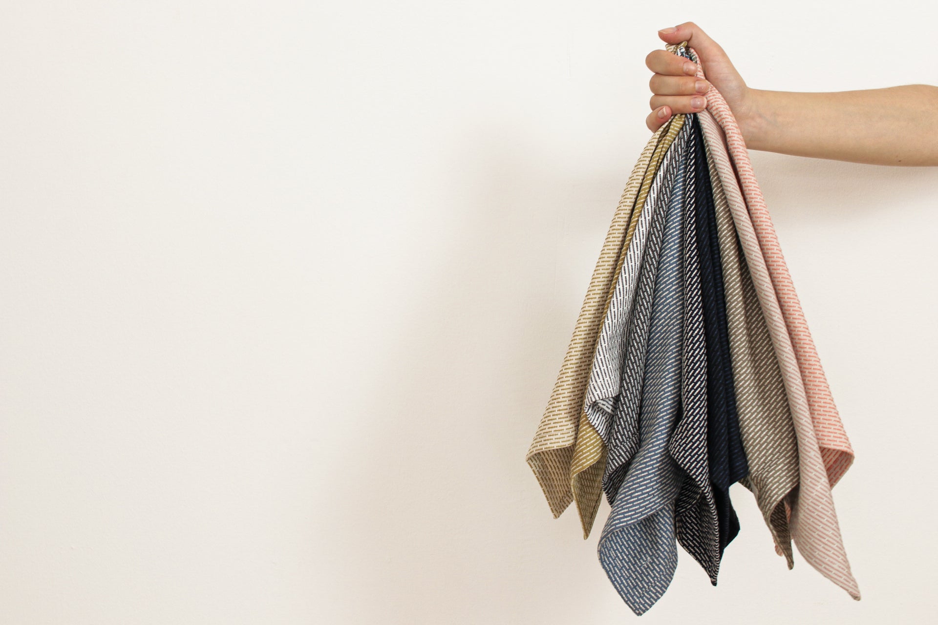 Hand holding towels in different colours