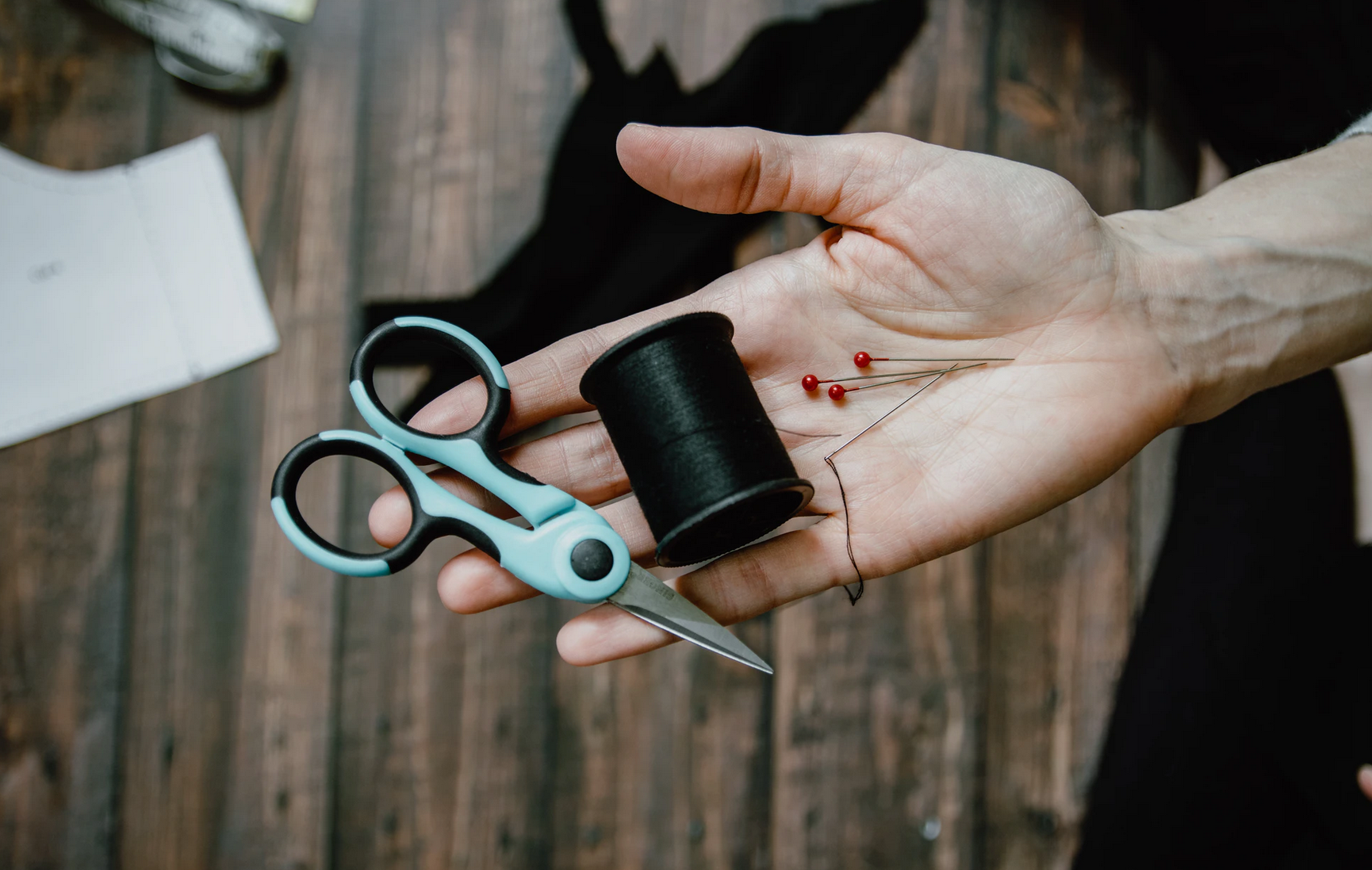 Hand holding scissor and thread